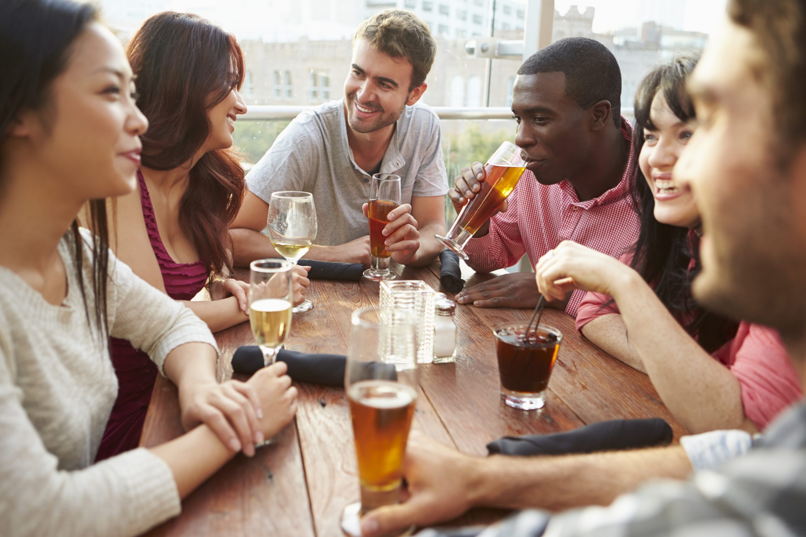 group of people at wooden table drinking beer