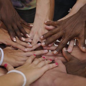 many different races of hands joining in circle