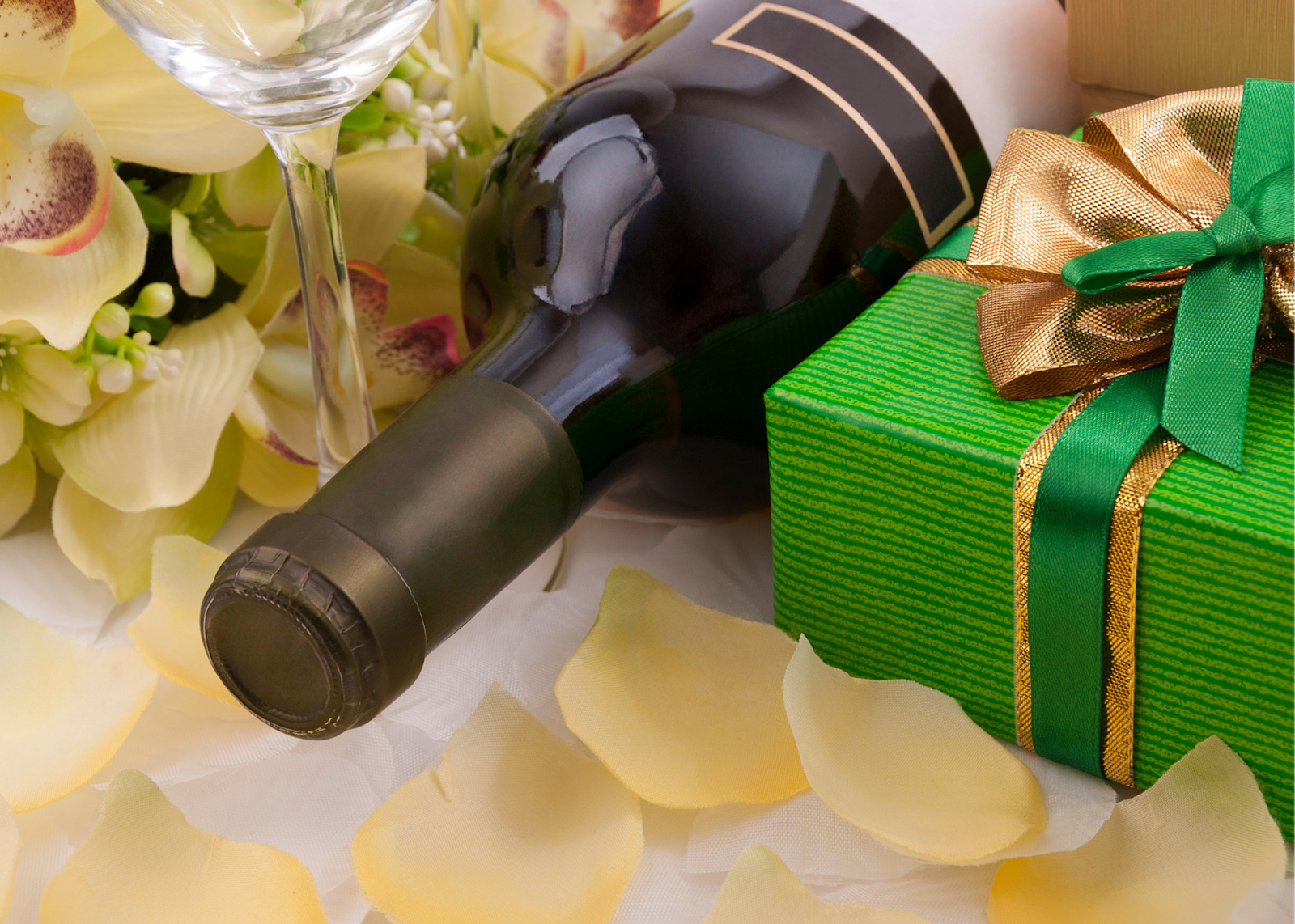 bottle of wine beside a green gift box